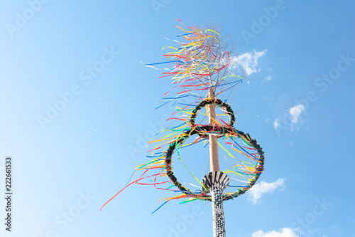 typical greman may pole or maibaum at the festival in front of blue sky, spring holiday concept photo