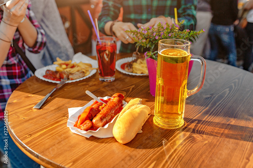 Obraz na plátně Curry wurst Sausages with beer on the table in outdoor restaurant