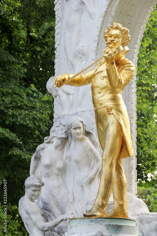 Obraz premium The golden statue of the great musician Johann Strauss in the city park, Vienna, Austria (built in 1921)