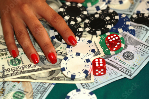 Fotografi Woman playing craps with cash and chips on the green casino table