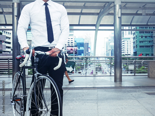 Business man and bicycle walking on street and building background.