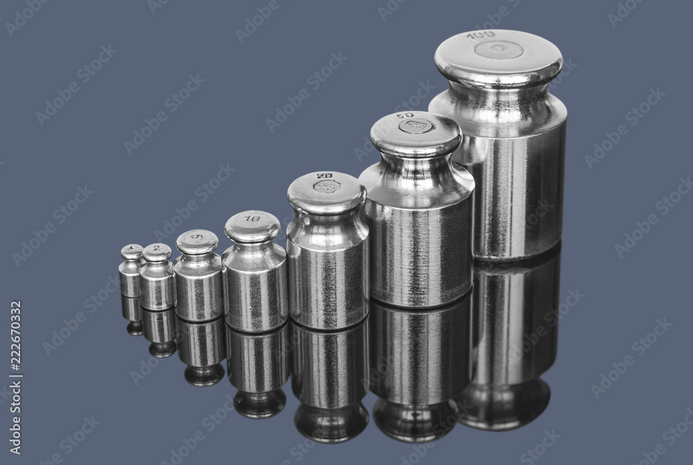 Set of metal weights for laboratory scales on dark background Set of metal weights for laboratory scales on dark background