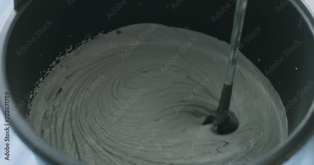Slow motion closeup mixing black ink to micro concrete plaster Slow motion closeup mixing black ink to micro concrete plaster