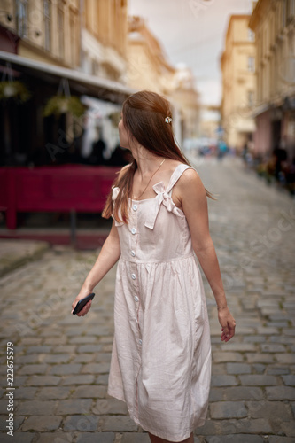 young woman walking on the street and looking back