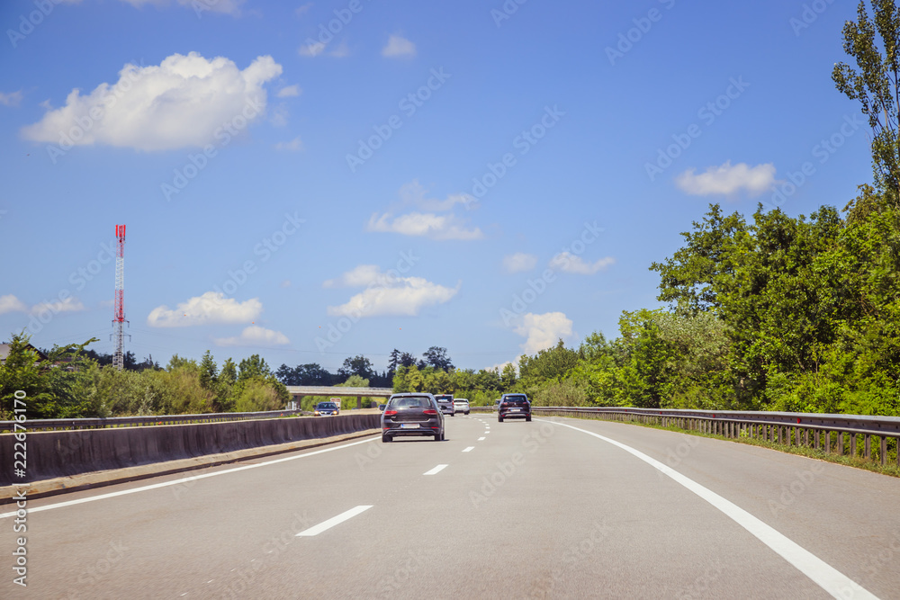 Fototapeta premium Verkehr auf Autobahn, Asphalt, Autos und blauer Himmel