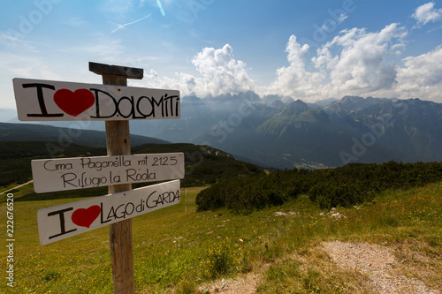 Italy. Dolomites. View from the mountain Paganella. On the left is a nameplate with the name of the area. Summer period. photo