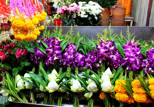 Bouquets of yellow marigolds, purple orchids and white lotuses for Buddha worship in Thailand. 