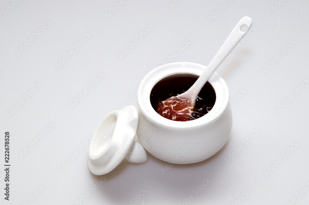 Close up porcelain rosette with rose jam on white background. Close up porcelain rosette with rose jam on white background.
