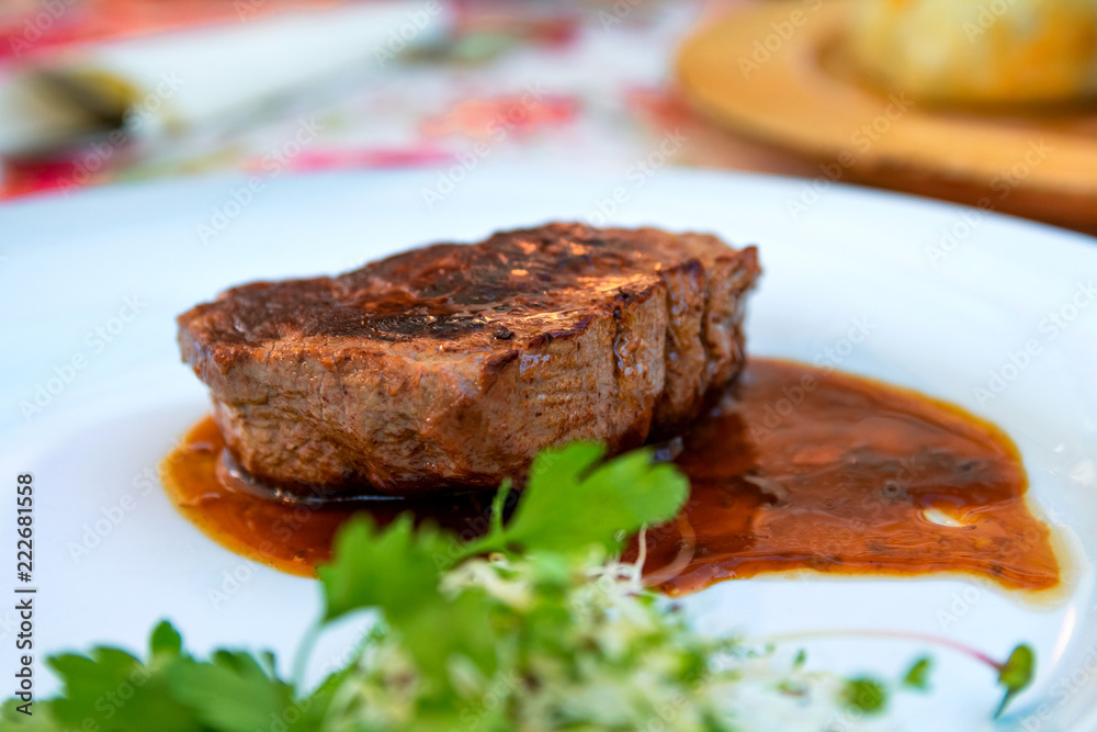 Grilled steak beef with sauce served on a white plate Grilled steak beef with sauce served on a white plate