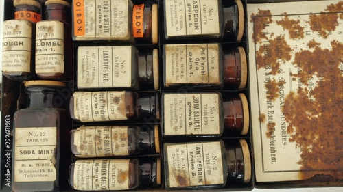 Opening an antique medicine set from early 20th century.  Many are now considered poisons. Some early synthetic analgesics, Aspirin, sodium salicylate and Antifebrin (Acetanilide) in top row.  photo