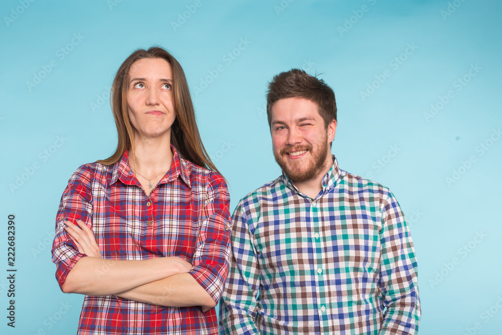 Funny young couple laughing and fooling around together on blue background. Funny young couple laughing and fooling around together on blue background.
