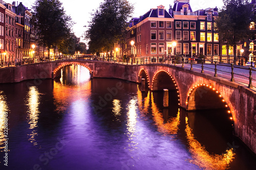 Amsterdam evening with bridges, canals and lights at sunset