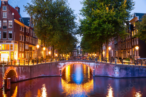 Amsterdam evening with bridges, canals and lights at sunset
