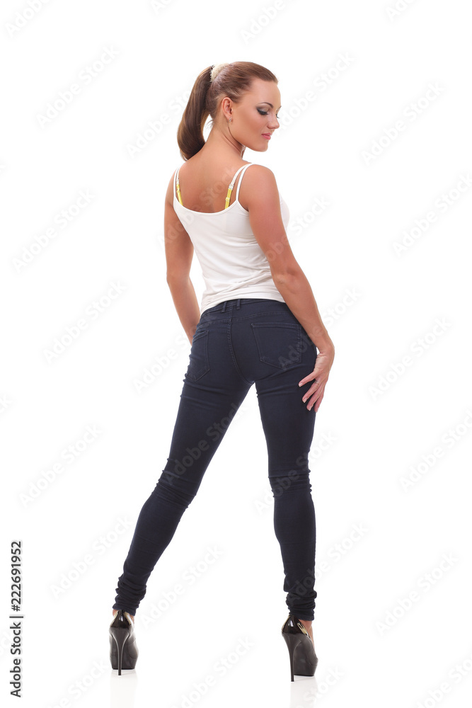 Full length portrait woman in a white tank top and jeans.