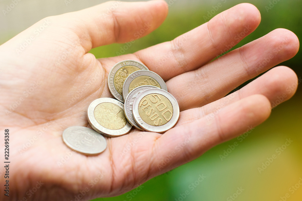 Fototapeta premium Colombian peso coins in man's hand