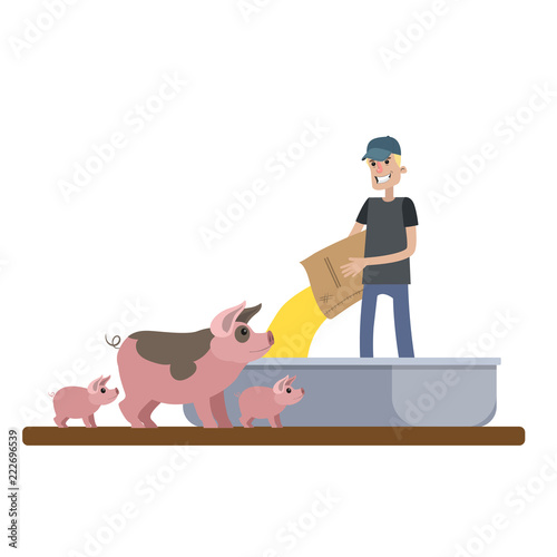 Smiling male farmer feeding pig on the farm