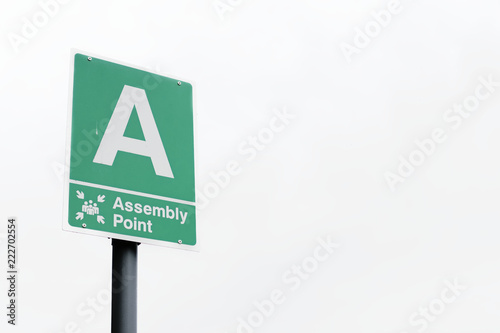 Fire assembly point sign at workplace in empty sky