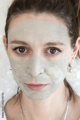 Portrait of a girl with a clay mask on the face