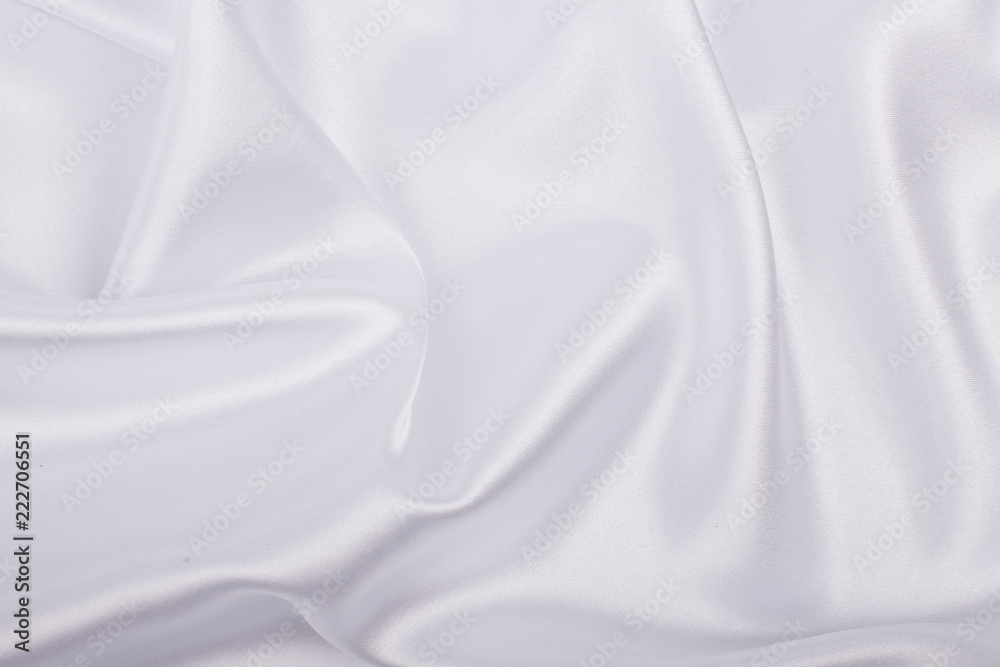White satin fabric as background. Abstract luxury cloth or liquid wave.