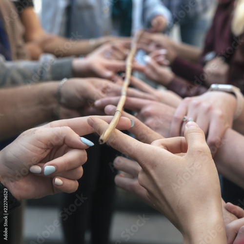 conceptual image of teamwork, a group of people holding sticks holding a bamboo branch.