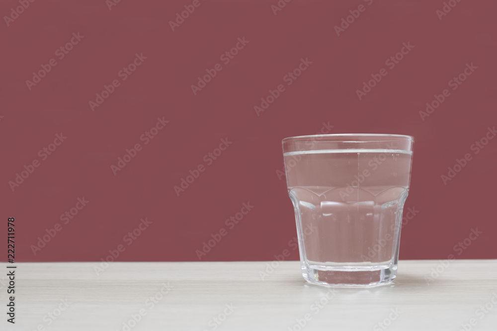 Clear glass of water against empty blue background Clear glass of water against empty blue background