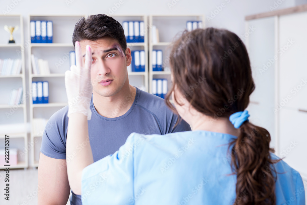 Fototapeta premium Young man visiting female traumatologist with black eye 