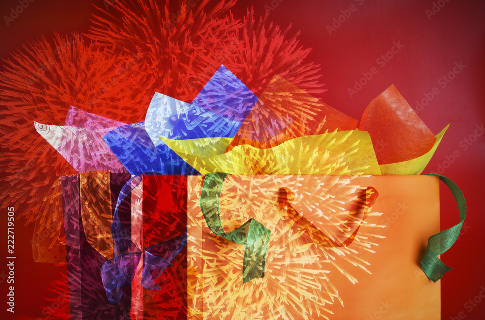 Colorful shopping bags, wrappnig papers and ribbons overlayed by fireworks