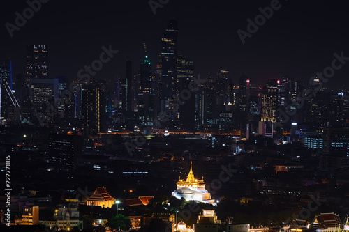 night aerial view of golden temple in modern cityscape