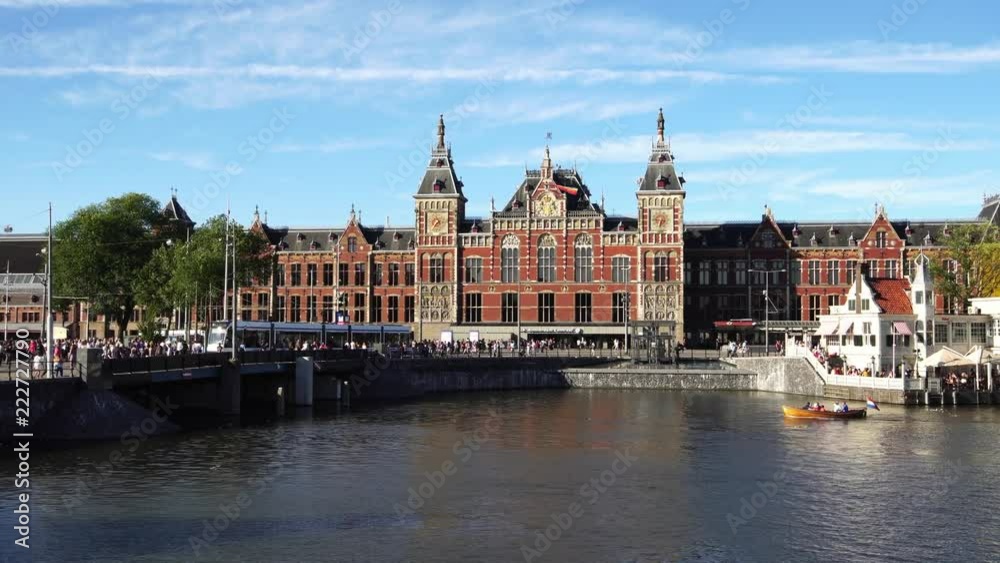 Traditional boat at the canal waterfront in front of Amsterdam Central station, Europe. Traditional boat at the canal waterfront in front of Amsterdam Central station, Europe.