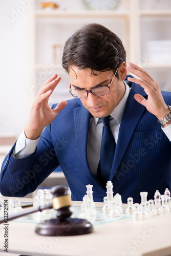 Young lawyer playing chess to train his court strategy and tacti photo