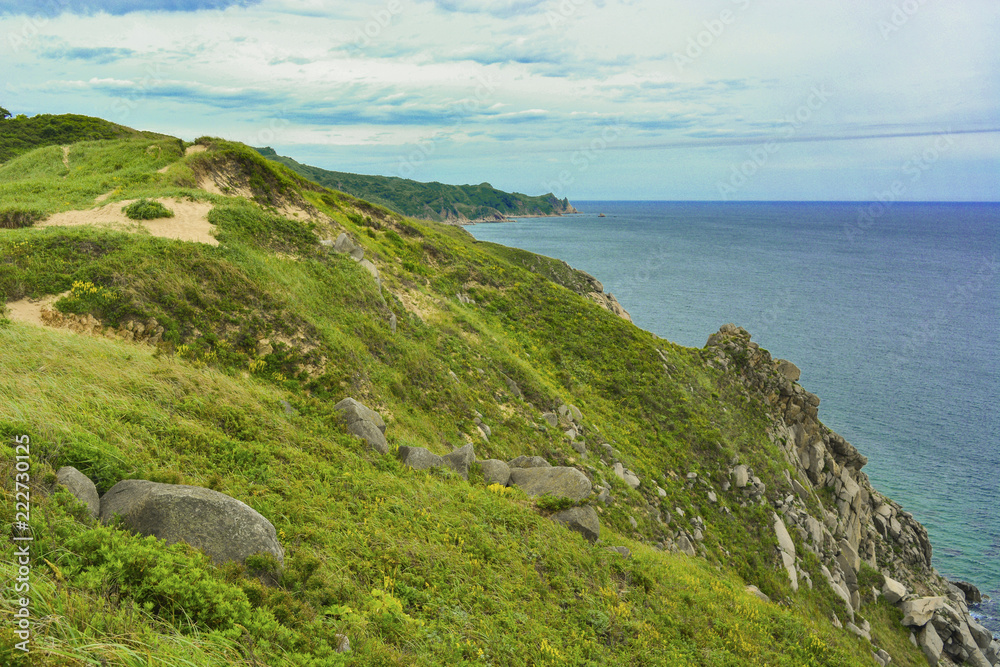 View from a green rocky hill to the sea. Summer landscape.
