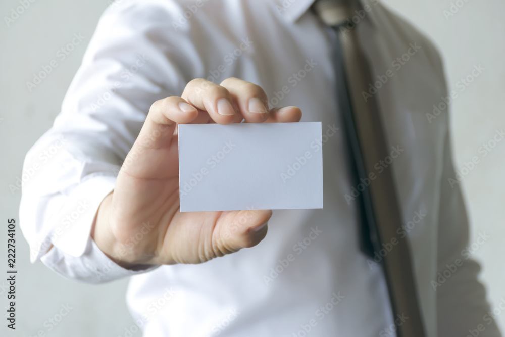 Businessman holding a white business card.