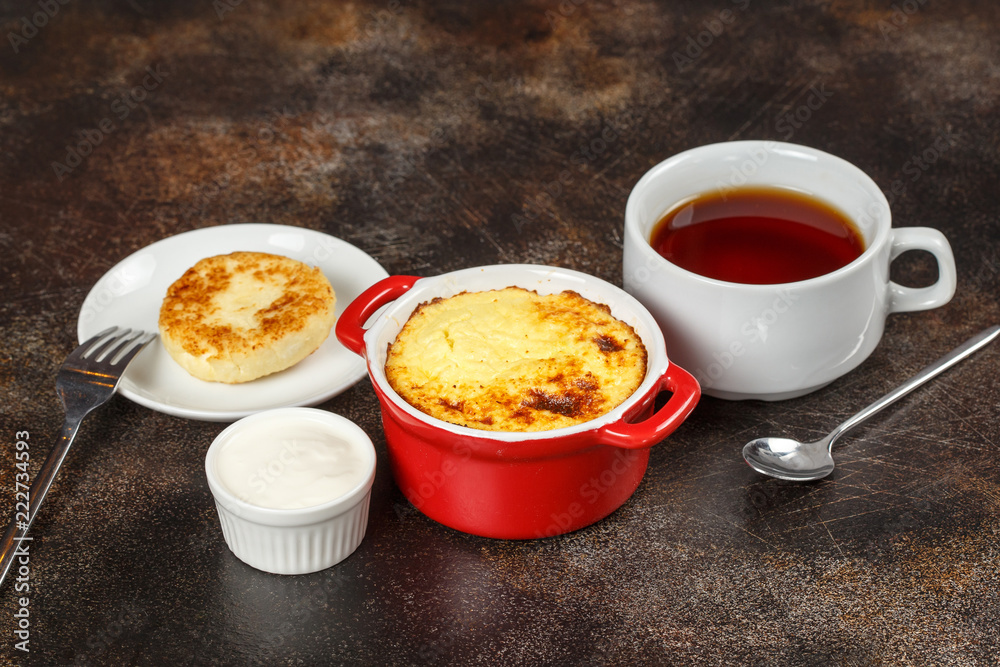 Baked omelet with golden crust in bowl with tea