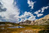 A beautiful landscape of mountains and lakes on a partly cloudy day in late summer.