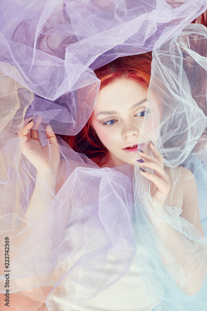 Redhead Girl dreams, bright makeup, clean skin, facial care. Redhead girl in a light air colored dress lies on the floor, a portrait close-up. Romantic woman with long hair and cloud dress Redhead Girl dreams, bright makeup, clean skin, facial care. Redhead girl in a light air colored dress lies on the floor, a portrait close-up. Romantic woman with long hair and cloud dress