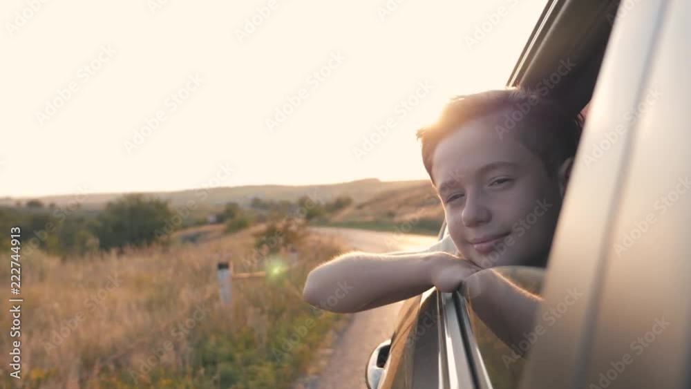 Teen boy looking out the car window. Summer trip with family