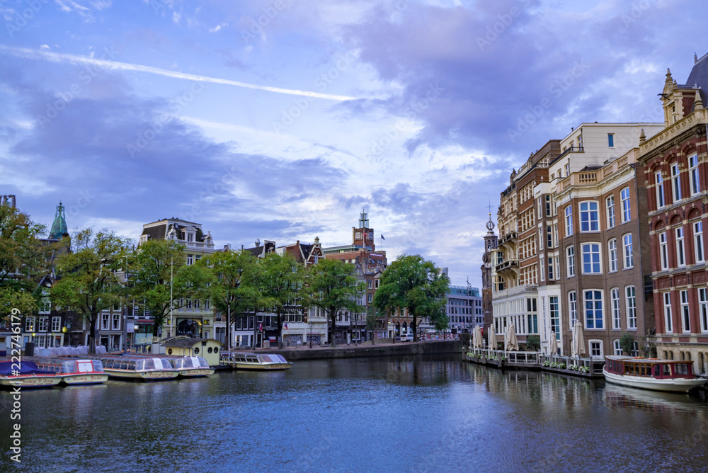朝日に照らされるアムステルダムの川と街並み