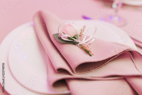 Dining table setting at Provence style  with small rose flower  beige napkin. Close-up horizontal view