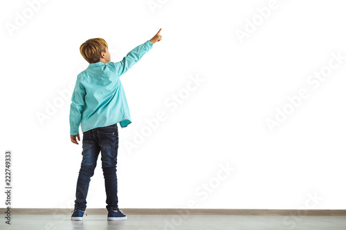 The little boy gesturing on the white wall background