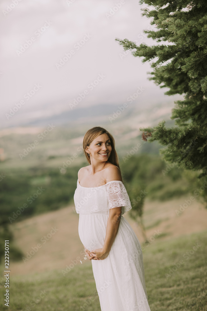 Young pregnant woman relaxing outside in nature Young pregnant woman relaxing outside in nature