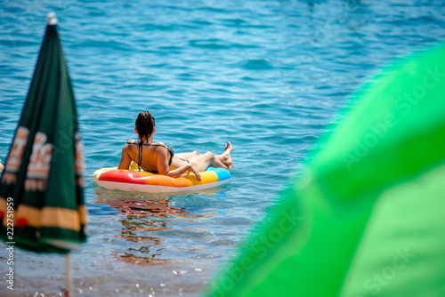 Girl bathing in the sea on an inflatable mattress  © licvin