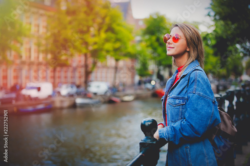 Photography Young girl in red sweater and orange sunglasses with backpack at bridge in Amsterdam street