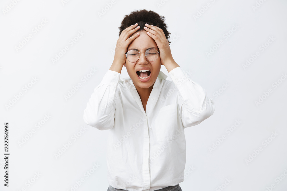 Hold on, I need break. Tired distressed upset african-american female in glasses, closing eyes, yelling from painful feeling, holding hand on head, losing important deal, devastated and displeased Hold on, I need break. Tired distressed upset african-american female in glasses, closing eyes, yelling from painful feeling, holding hand on head, losing important deal, devastated and displeased