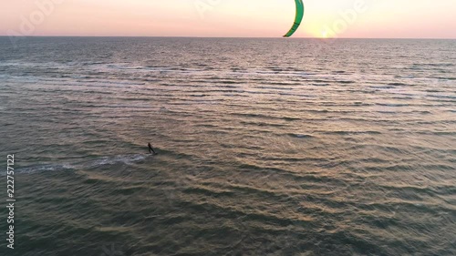 Top view, male kite is engaged in kitesurfing in the sea during sunset photo