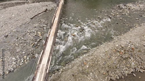 Flying over a rickety suspension footbridge crossing the Rio Cosanga on the Amazonian slopes of the Andes in Ecuador. photo