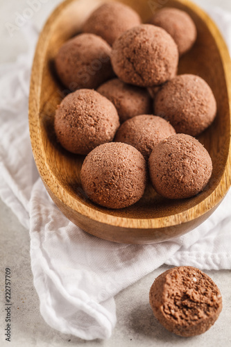 Raw vegan balls from nuts and cocoa in a wooden bowl.