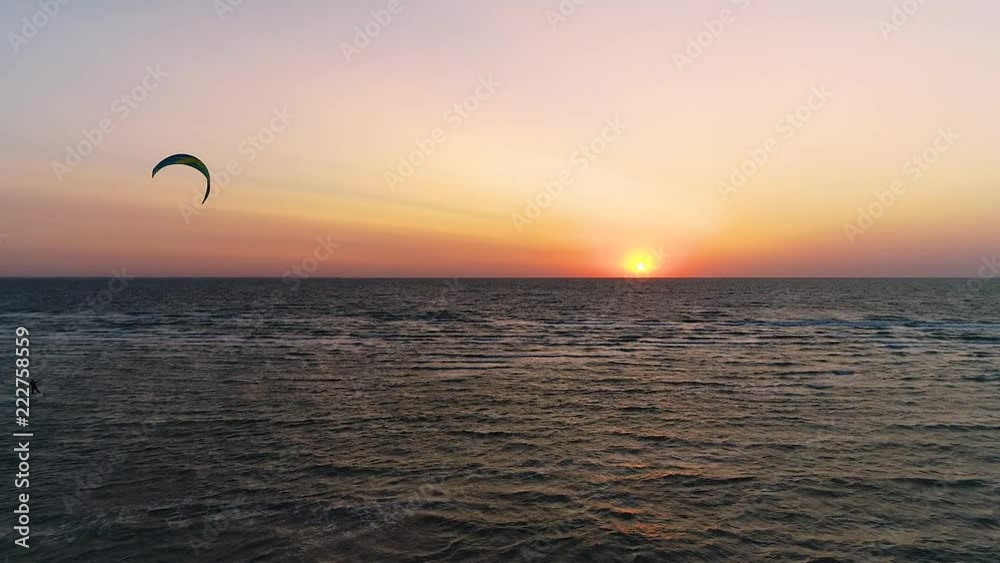 Silhouette of kiter in the sea at sunset time, aerial view Silhouette of kiter in the sea at sunset time, aerial view