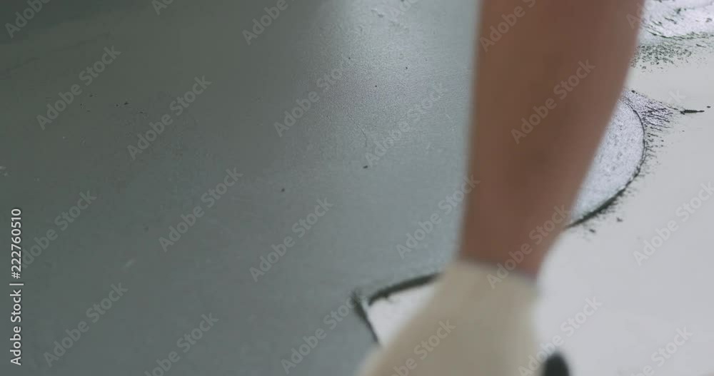 Slow motion closeup male worker applying micro concrete plaster coating on the floor with a trowel