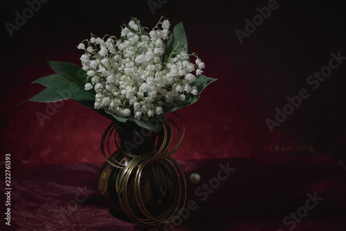 A bouquet of lilies of the valley in a vase.