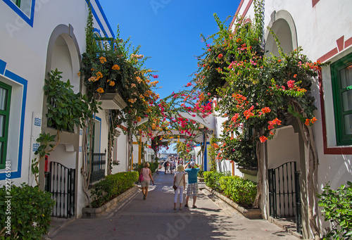 Fototapeta Naklejka Na Ścianę i Meble -  Beautiful narrow street in Canary Islands, Spain, walls covered with bougainvillea colorful flowers